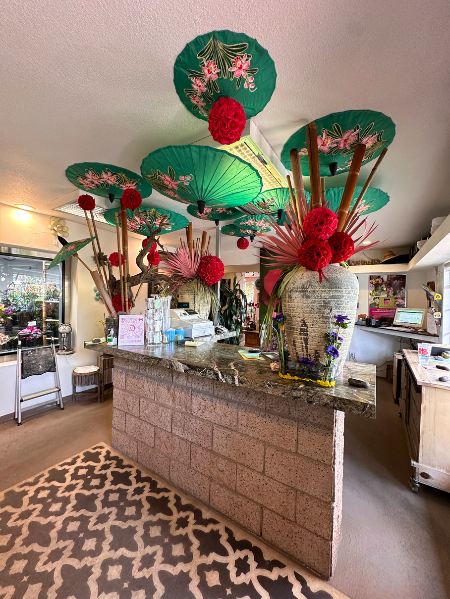 The ornately decorated sales counter at Lotus Garden Center in Palm Desert featuring upside-down parasols and fake flowers.