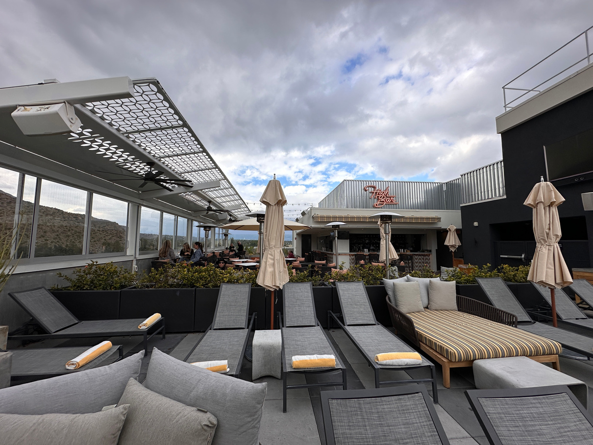 The High Bar rooftop lounge at The Rowan hotel in downtown Palm Springs, showing pool chaises and outdoor seating.