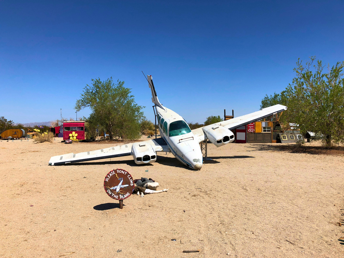 A plane with its nose touching the dirt on display at the open-air art museum known as East Jesus in Slab City.