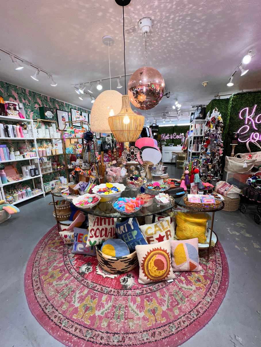 The interior of Kat & Cody in Palm Springs showing the central display of funky gifts topped by a large pink disco ball.
