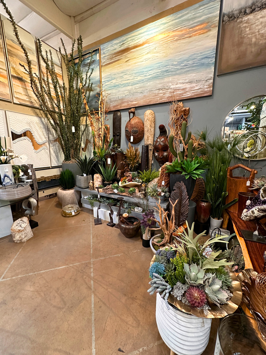A display room at the Art in Nature designer showroom in Palm Desert, featuring large paintings and faux succulent displays.