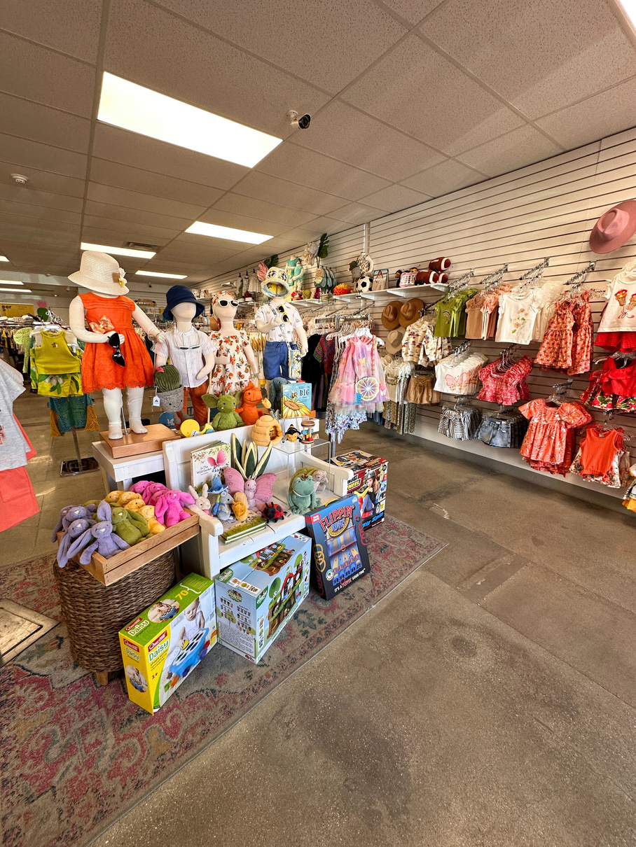 The interior of JadaBug's Kids Boutique in La Quinta showing children's clothing and stuffed animals.